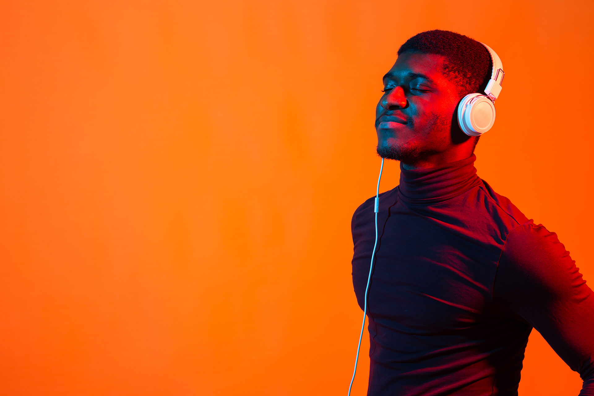 Neon portrait of young african man listening music with earphones